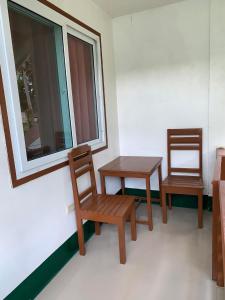 a room with two chairs and a table and a window at Divinagracia Cottages in San Vicente