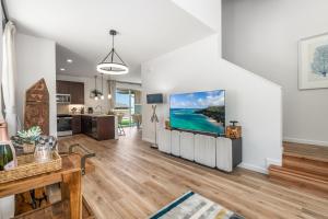 a living room with a large tv on a wall at @Marbella Lane - 7BR home w/ Mountain+Ocean Views in Waianae