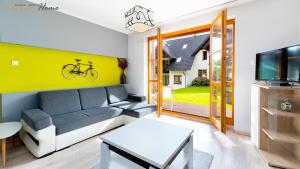 a living room with a couch and a bike on the wall at Wonder Home - Domki górskie na osiedlu dozorowanym, z kominkami i placem zabaw in Karpacz