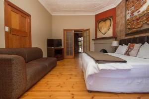 a bedroom with a large bed and a couch at Saffron Guest House in Johannesburg