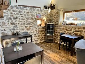 un restaurante con 2 mesas y una pared de piedra en Moulin des Comtes - chambre des comtes, en Viverols
