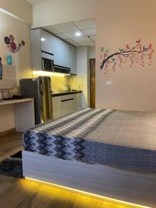 a room with a bed in a kitchen with a refrigerator at Serene Stay India in Greater Noida