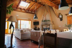 a living room with a table and chairs and a fireplace at LA SOLANILLA -Casas Rurales in Torre Val de San Pedro +38 photos