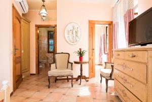 uma sala de estar com uma televisão e uma mesa e cadeiras em Hotel Monte Cristo em Kotor