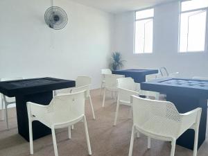 a dining room with white chairs and blue tables at TZ SATELLITE HOTEL, Kota Bharu in Kota Bharu