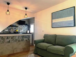 a living room with a green couch and a kitchen at Home SEA&DREAMS OldTown V in Calpe