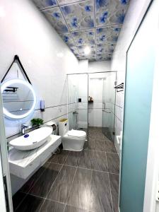 un bagno con lavandino, WC e specchio di Green Jungle Homestay - Phù Hợp Gia Đình Từ 10 - 15 Người Lớn & 5 Trẻ Em - Bãi Đậu Xe Ô Tô, Sân BBQ - Miễn Phí Sử Dụng Dịch Vụ Hồ Bơi Cách Homestay 3 Phút Đi Bộ - 7 Phút Đi Bộ Đến Biển - 5 Phút Đến Chợ Hải Sản Phú Thuỷ a Phan Thiet