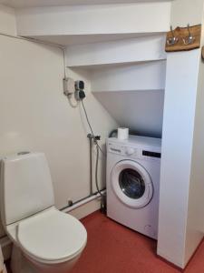 een badkamer met een toilet en een wasmachine bij Skölvs Gård in Glanshammar