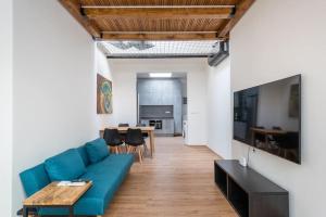 a living room with a blue couch and a table at Astronomical Clock Apartment in Prague