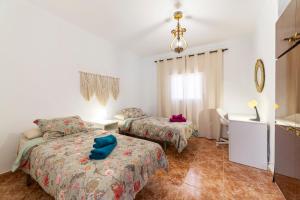 a bedroom with two beds and a couch and a desk at Mi Locura Costa Cabana in Almería