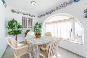 a dining room with a table and chairs and a window at Mi Locura Costa Cabana in Almería