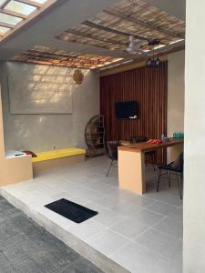 a living room with a yellow table and a tv at Pranajayaloka private villa in Tejakula