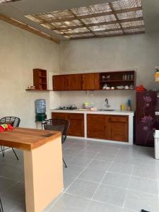 a large kitchen with a table and a refrigerator at Pranajayaloka private villa in Tejakula