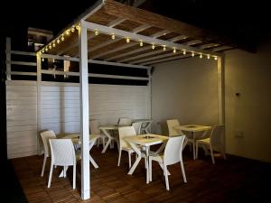 a dining room with tables and chairs and lights at Affittacamere Vicino al Porto in Porto Torres