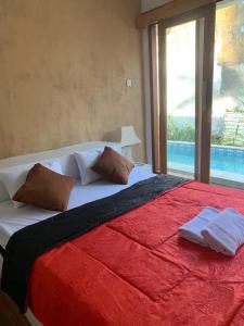 a bedroom with a large red and white bed with a window at Pranajayaloka private villa in Tejakula +22 photos