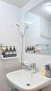 a white bathroom with a sink and a mirror at Evermore #Sinchon station 5min #Seogang station 1min in Seoul