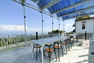un patio con tavoli, sedie e vista sull'oceano di Villa Madasaeda by GroRental a Panjadakan