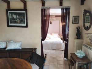 a bedroom with a bed and a table in a room at La Vendemiere - Maison d'hôtes de charme et de caractère, Bretagne, Côtes d'Armror in Pont-Melvez