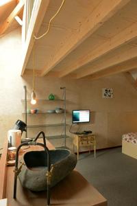 a living room with a chair and a tv at Historische Boerderij FAMILIEKAMER in Heinkensand