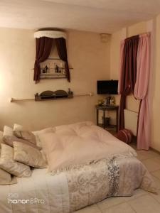 a bedroom with a large white bed with pink curtains at La Vendemiere - Maison d'hôtes de charme et de caractère, Bretagne, Côtes d'Armror in Pont-Melvez