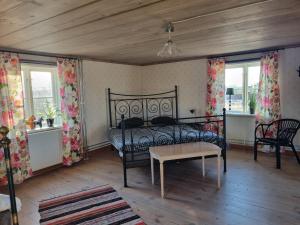 1 dormitorio con cama, mesa y ventanas en Skölvs Gård, en Glanshammar