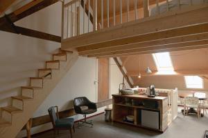 a room with a staircase and a table and chairs at Historische Boerderij FAMILIEKAMER in Heinkensand