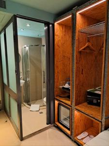 een badkamer met een douche en een glazen deur bij IND Hotel in Hong Kong