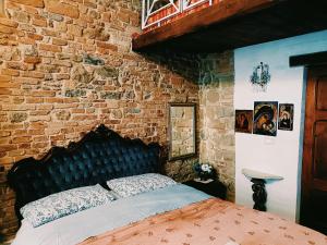 una camera da letto con un letto in un muro di mattoni di Old Style Studio a Perugia