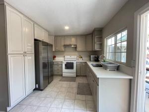 a kitchen with wooden cabinets and white appliances at Spacious 1670 sq ft Single Home with Garage, AC, Centrally Located in San Diego