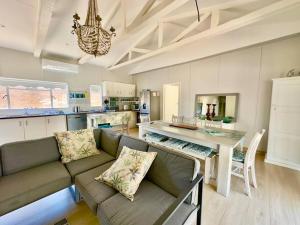 a living room with a couch and a table at The Perfect Hartenbos Holiday Home in Mossel Bay