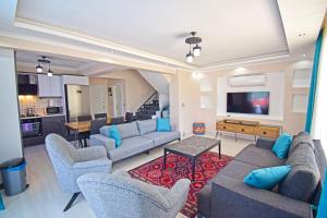 a large living room with couches and a tv at Villa Kozalak 1 in Fethiye