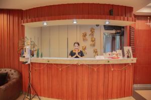 a woman sitting at a counter in front of a mirror at The Sunreno Hotel SHA in Bangkok