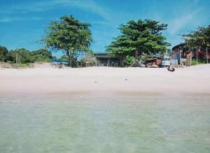 a view of a beach with trees in the distance at Nadan Beach House in Ban Thung O