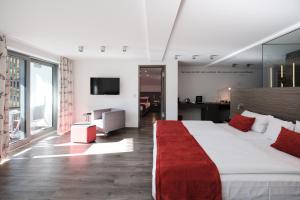 - une chambre avec un grand lit et une couverture rouge dans l'établissement Hotel Traube Tonbach, à Baiersbronn