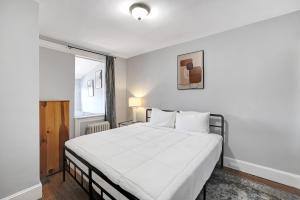 una camera da letto bianca con un letto grande e una finestra di Spacious Brookland home a Washington