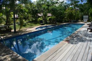 uma piscina com um deque de madeira e água azul em Eden Island Apartment 70A14 em Eden Island