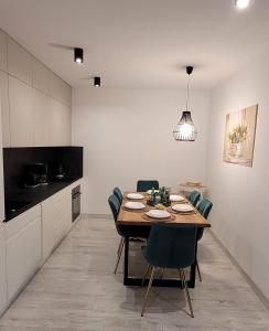 a kitchen and dining room with a table and chairs at Horyzont Apartamenty-ANTON-Piękny apartament blisko centrum, dwie sypialnie, prywatny garaż in Kołobrzeg