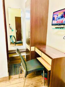 escritorio con silla y espejo en la habitación en HOTEL SUNSHINE, en Nagpur