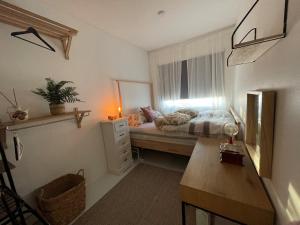 a small bedroom with a bed and a window at Arctic Homestay with Northern light view room in Tromsø
