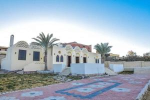 قرية تونس في Tunis: بيت ابيض امامه اشجار النخيل