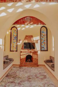a living room with a brick fireplace and two windows at قرية تونس in Tunis