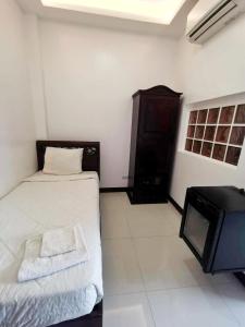 a bedroom with a bed and a tv in it at MJ Pension House in Talisay