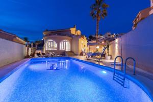 a swimming pool in front of a house at The Big Chill by Fidalsa in Rojales