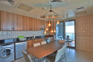 eine Küche mit einem Tisch und einem Esszimmer in der Unterkunft Stunning Marina View! Solo Room in Shared Apartment at Luxurious Princess Tower in Dubai