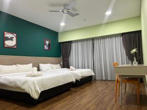 Habitación con 2 camas, paredes verdes y escritorio. en Summer Suites KLCC By Castle Classy en Kuala Lumpur
