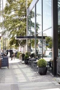 a sidewalk with tables and chairs in front of a building at Hotel Østerport in Copenhagen