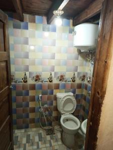 a bathroom with a toilet and a colorful tiled wall at Omar Oasis in Siwa