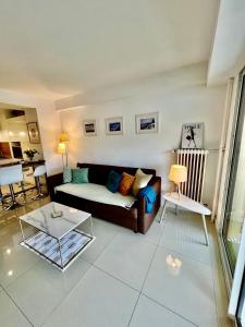 a living room with a couch and a table at Appartement Cosy Calme Central-Terrasse Proche Palais in Cannes