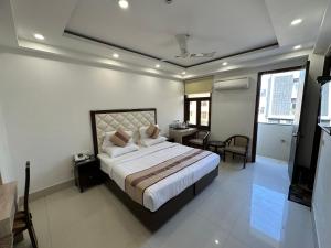 um quarto com uma cama grande, uma mesa e cadeiras em Lemon Green Residency - Hotel and Serviced Apartments em Nova Deli