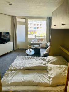 ein Schlafzimmer mit einem Bett und ein Wohnzimmer in der Unterkunft Strandhafer in Wendtorf